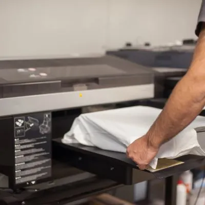 Persona colocando camiseta en máquina para vinilar